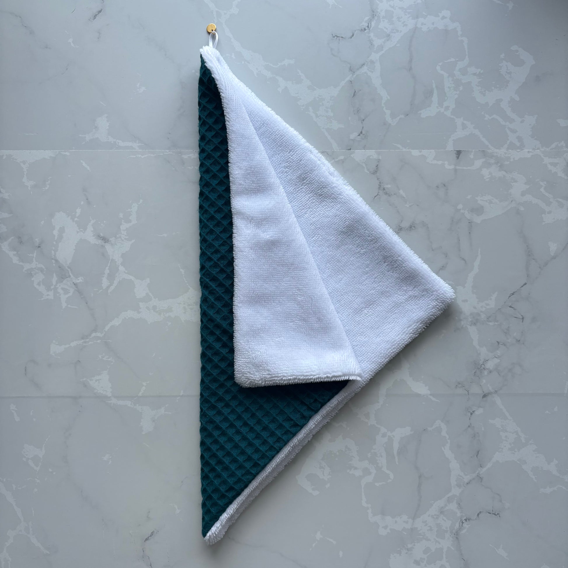 serviette visage en éponge bambou blanc et nid d'abeille bleu carnard avec un logo médaillon.