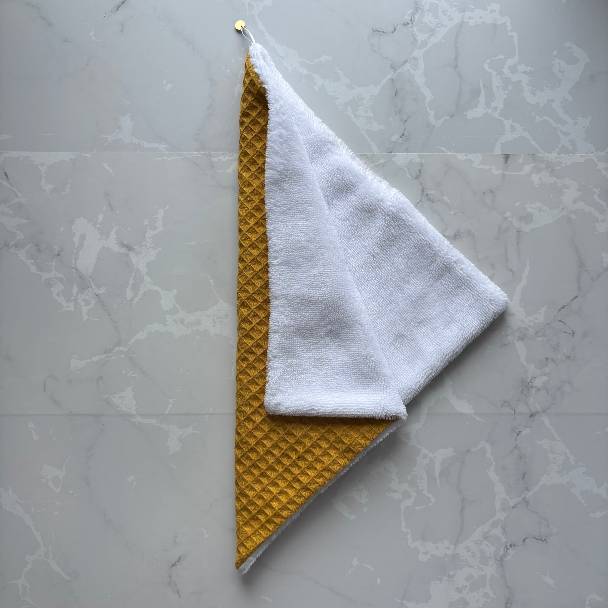 serviette visage en éponge bambou blanc et nid d'abeille moutarde avec un logo médaillon.